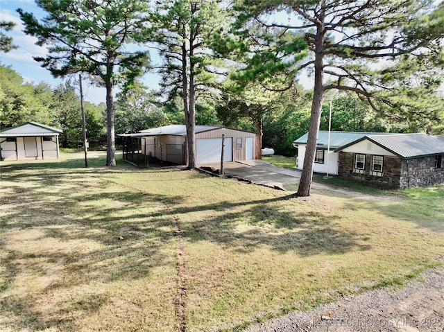 view of yard with an outbuilding, a garage, and a carport