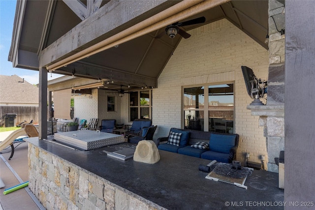 view of patio featuring a bar, ceiling fan, and an outdoor living space