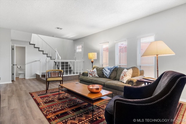 living room featuring wood-type flooring and a textured ceiling