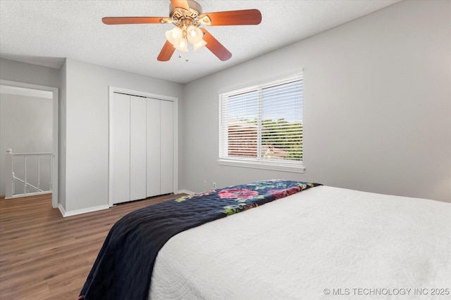 bedroom featuring hardwood / wood-style floors, a textured ceiling, a closet, and ceiling fan