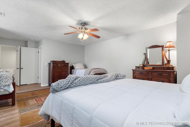 bedroom featuring ceiling fan, a textured ceiling, and hardwood / wood-style flooring