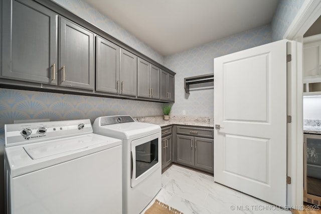 laundry room with washer and clothes dryer and cabinets