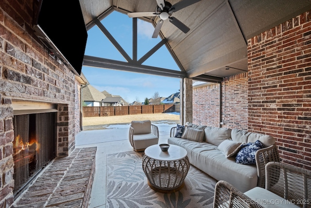 view of patio with an outdoor living space with a fireplace and ceiling fan