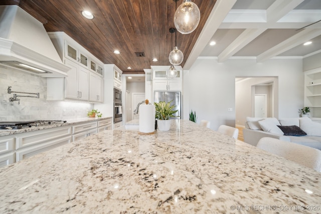 kitchen featuring white cabinets, appliances with stainless steel finishes, premium range hood, and hanging light fixtures