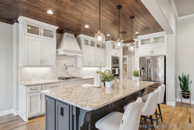 kitchen with a center island, stainless steel appliances, backsplash, white cabinets, and custom exhaust hood