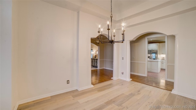 unfurnished dining area with light hardwood / wood-style floors and a notable chandelier