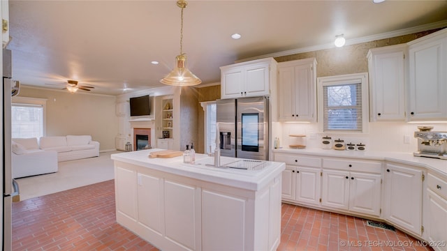 kitchen featuring white cabinets, stainless steel fridge with ice dispenser, and pendant lighting