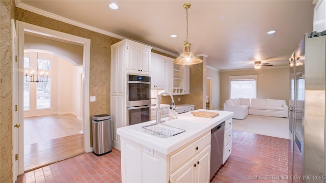 kitchen featuring appliances with stainless steel finishes, hanging light fixtures, ornamental molding, white cabinetry, and ceiling fan with notable chandelier