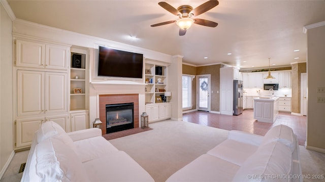 living room with ceiling fan, ornamental molding, and sink