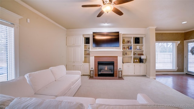 carpeted living room with ceiling fan and crown molding