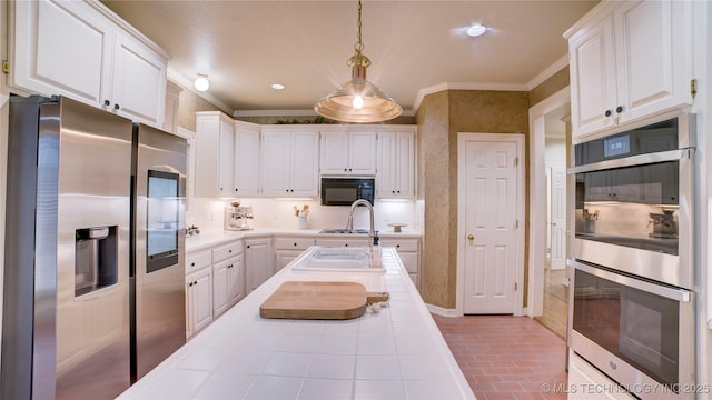 kitchen with stainless steel appliances, ornamental molding, sink, white cabinetry, and decorative light fixtures