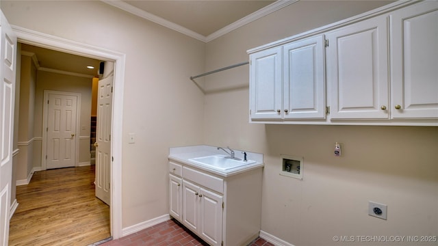 laundry room with hookup for an electric dryer, hookup for a washing machine, cabinets, ornamental molding, and sink