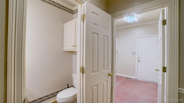 bathroom featuring toilet and ornamental molding