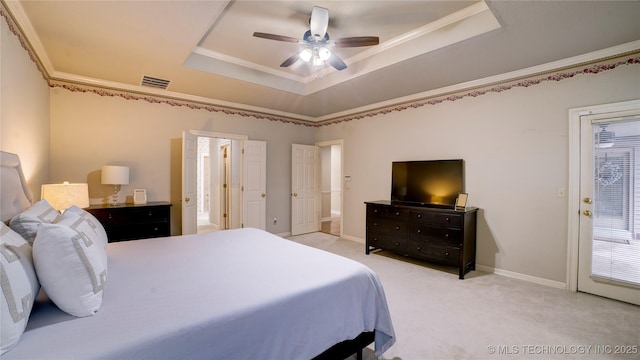 bedroom featuring light colored carpet, ceiling fan, a tray ceiling, and crown molding