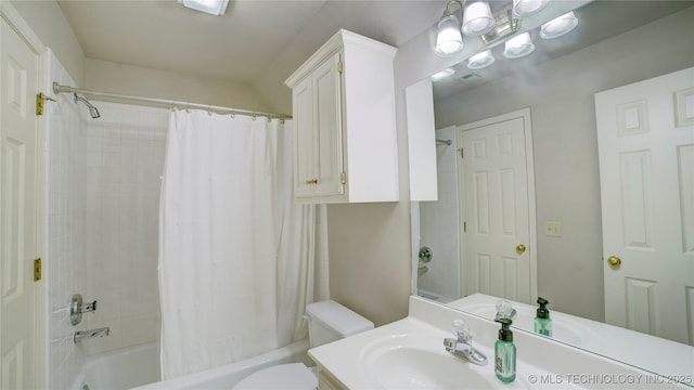 full bathroom with vanity, shower / bath combo with shower curtain, and toilet