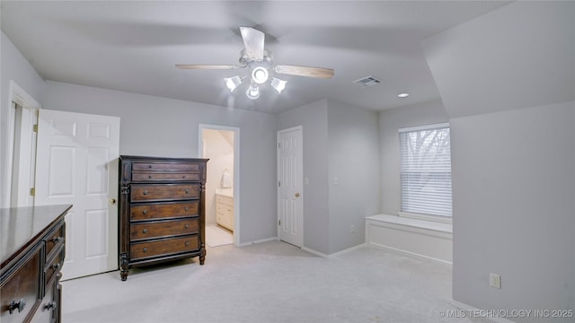 bedroom with ensuite bath, light carpet, and ceiling fan