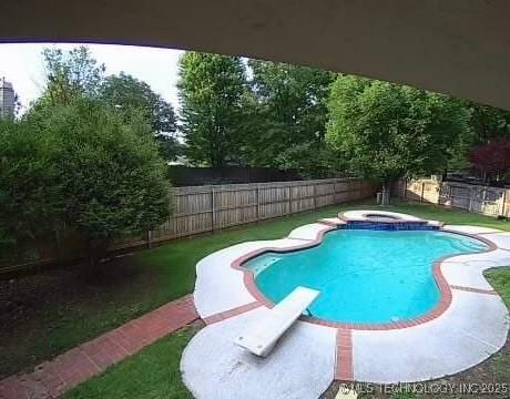 view of swimming pool with a diving board