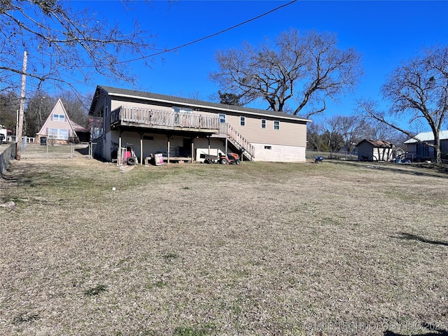 rear view of property featuring a lawn and a wooden deck