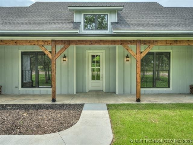 view of exterior entry with a yard