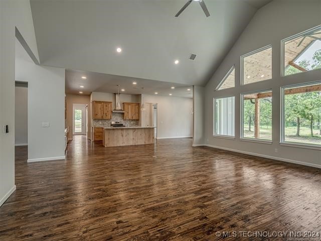 living room featuring dark hardwood / wood-style flooring, high vaulted ceiling, and ceiling fan