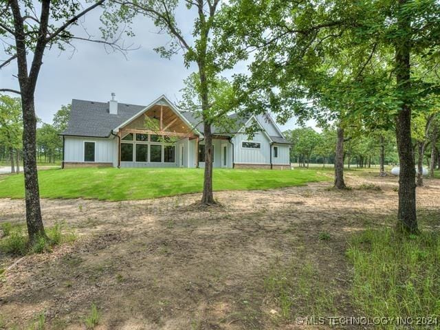 rear view of property featuring a lawn