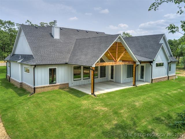 rear view of house with a yard and a patio