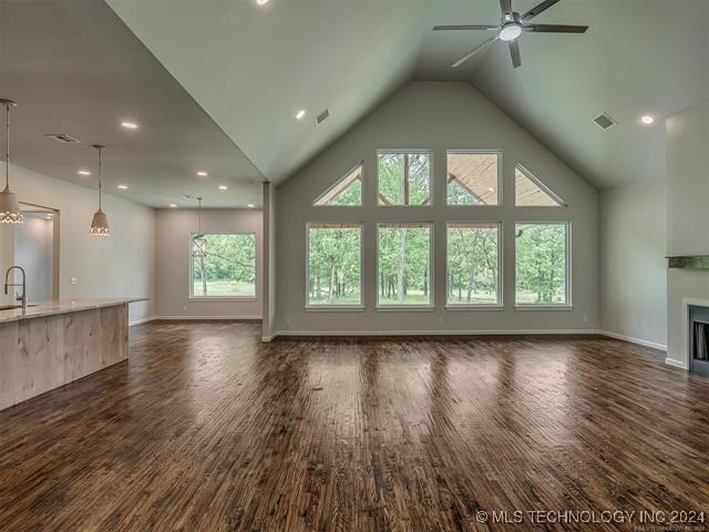 unfurnished living room with ceiling fan, dark hardwood / wood-style flooring, sink, and a wealth of natural light