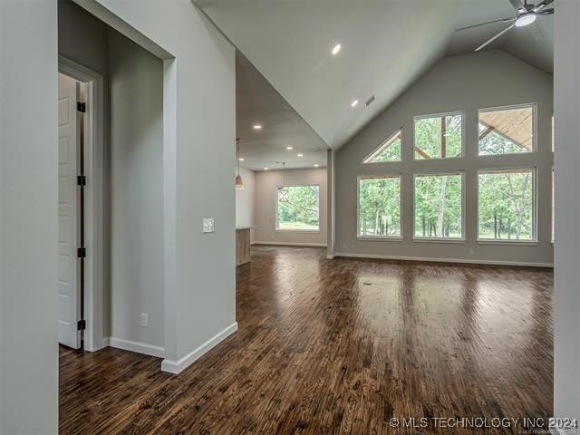 interior space featuring ceiling fan, dark hardwood / wood-style floors, a wealth of natural light, and vaulted ceiling