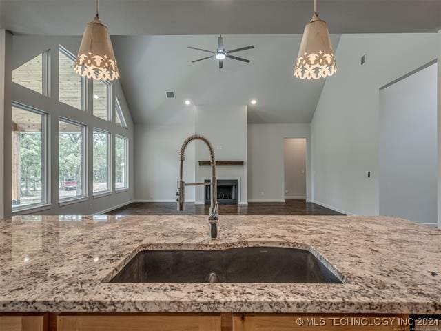 kitchen featuring ceiling fan, sink, high vaulted ceiling, and hanging light fixtures