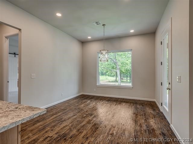 unfurnished dining area featuring dark wood-type flooring