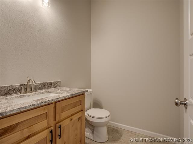 bathroom with tile patterned flooring, vanity, and toilet