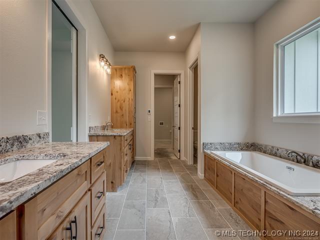 bathroom with a bathing tub and vanity