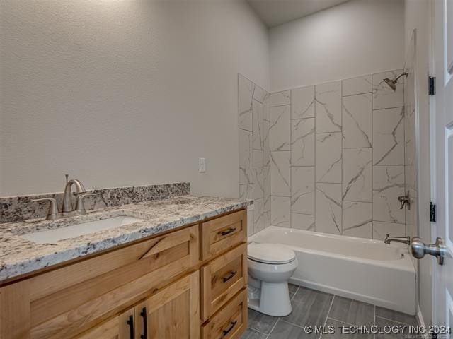 full bathroom featuring vanity, tiled shower / bath combo, and toilet