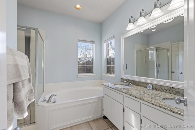 bathroom with plus walk in shower, vanity, and tile patterned flooring