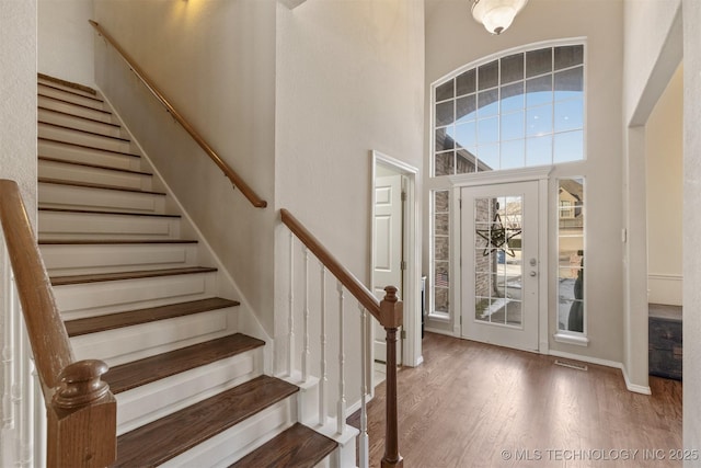 foyer featuring a towering ceiling and hardwood / wood-style flooring