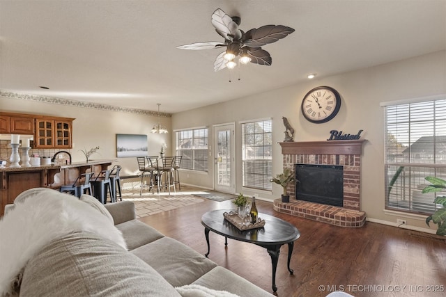 living room with a fireplace, dark hardwood / wood-style flooring, ceiling fan, and a healthy amount of sunlight