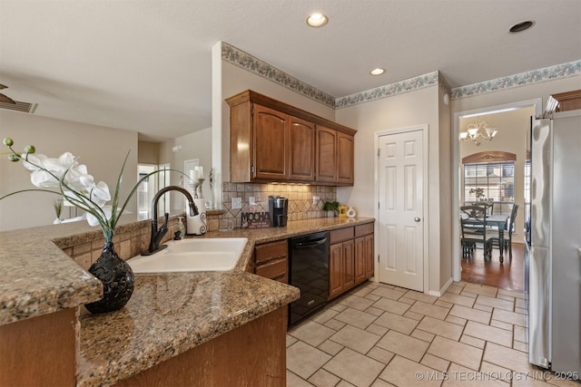 kitchen featuring decorative backsplash, stainless steel fridge, sink, an inviting chandelier, and black dishwasher