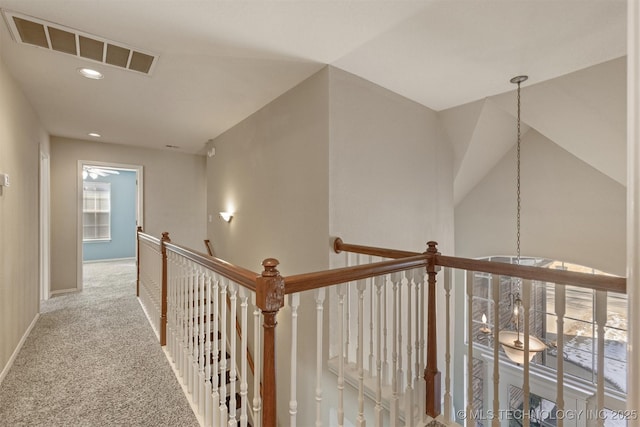 hall with light carpet and vaulted ceiling