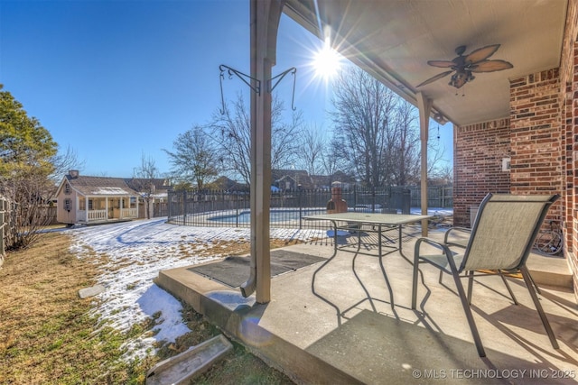 view of patio / terrace featuring ceiling fan, a community pool, and an outbuilding