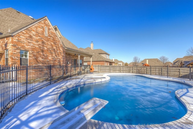 view of swimming pool with a diving board