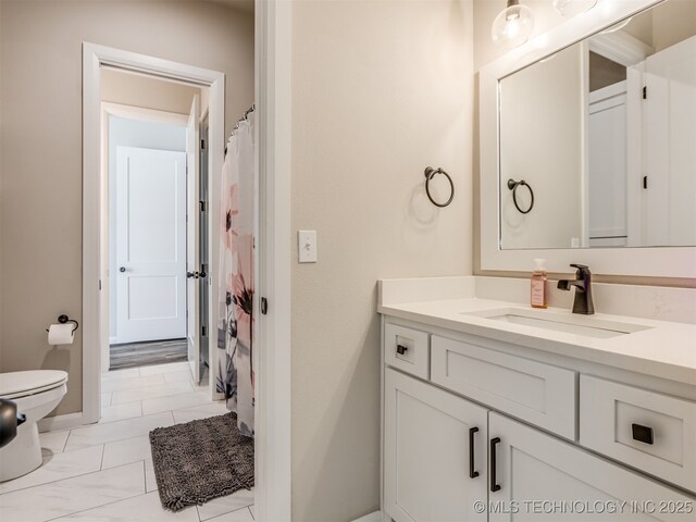 bathroom featuring tile patterned flooring, vanity, and toilet