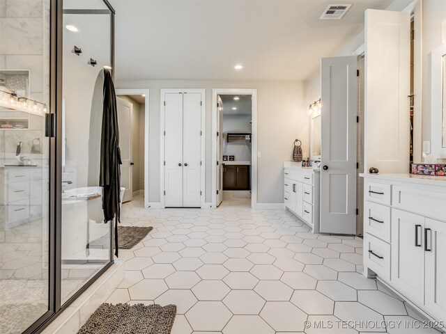 bathroom featuring a shower with door, vanity, and tile patterned flooring