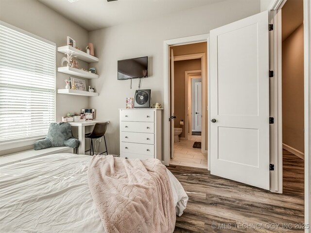 bedroom with dark wood-type flooring and ensuite bathroom