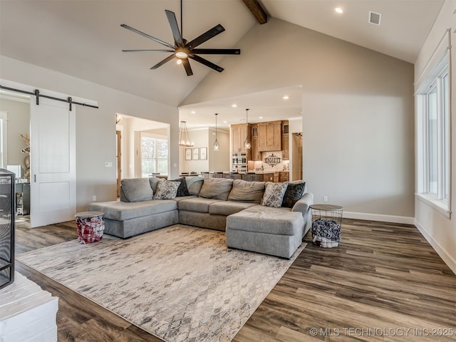 living room featuring a barn door, beamed ceiling, ceiling fan, dark wood-type flooring, and high vaulted ceiling