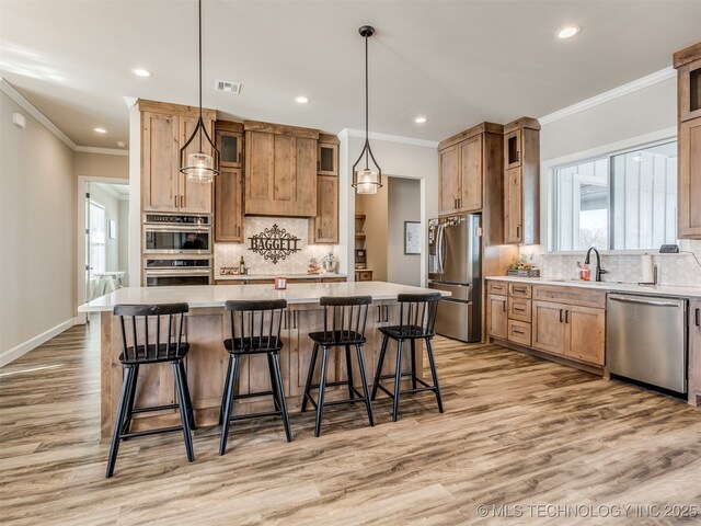 kitchen featuring a kitchen island, tasteful backsplash, hanging light fixtures, and appliances with stainless steel finishes