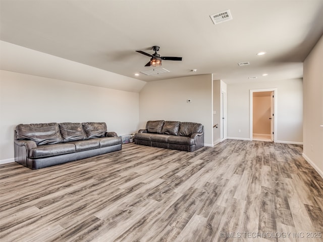 living room with ceiling fan, light hardwood / wood-style floors, and vaulted ceiling