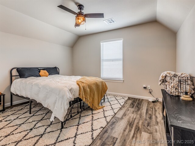 bedroom with ceiling fan, vaulted ceiling, and light wood-type flooring