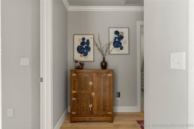 hallway with light hardwood / wood-style flooring and ornamental molding