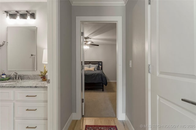 bathroom featuring wood-type flooring, vanity, ceiling fan, and crown molding