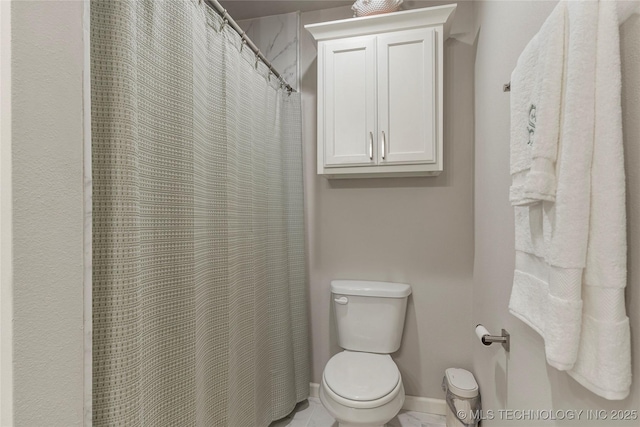 bathroom featuring toilet and curtained shower